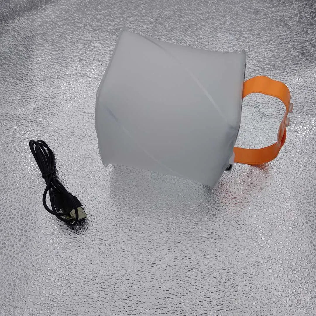 White solar inflatable waterproof camping LED lantern with handle, collapsed flat on a table