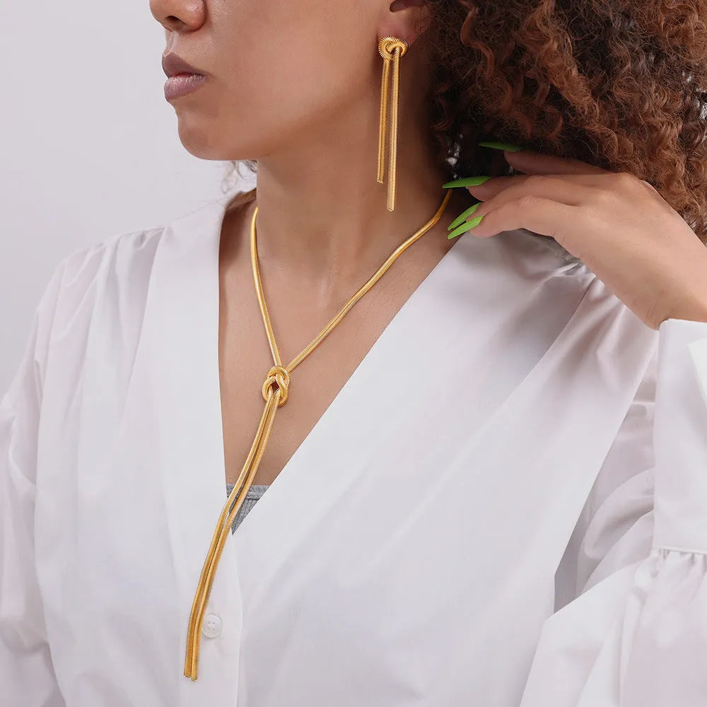 Gold electroplated titanium steel necklace with knotted tassel pendant on snake chain and matching earrings