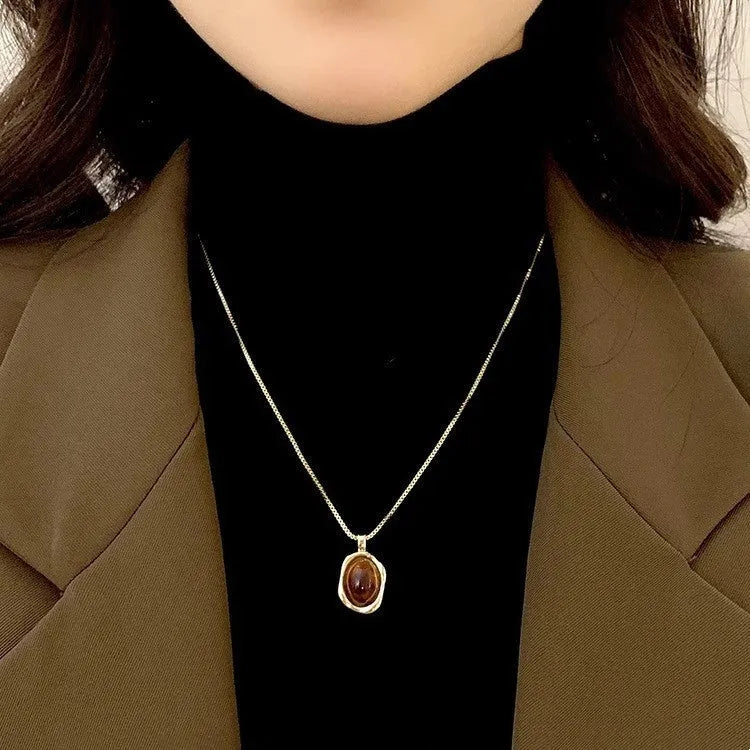 Women's geometric alloy pendant necklace with polished finish and gold copper clavicle chain on neutral background