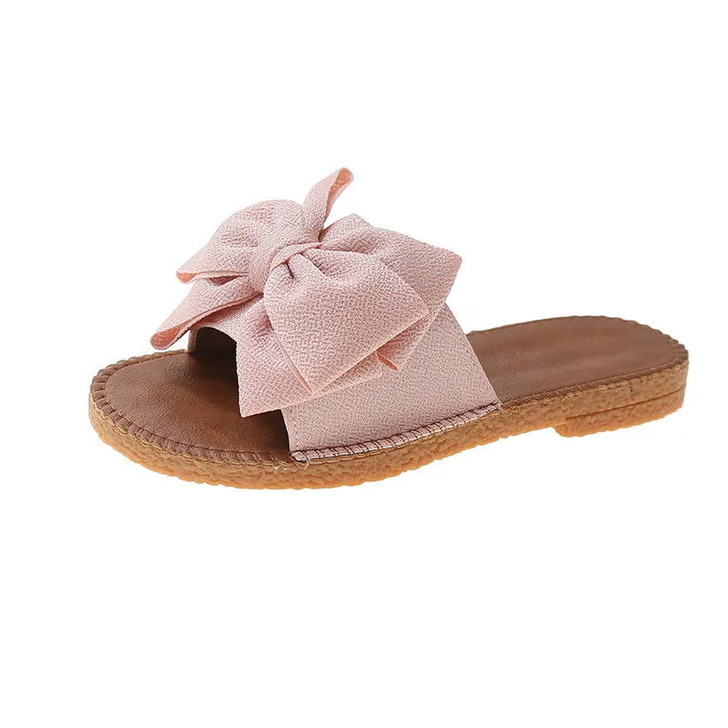 Women's slip-on cloth sandals with bow detail in beige, light green, and pink colours