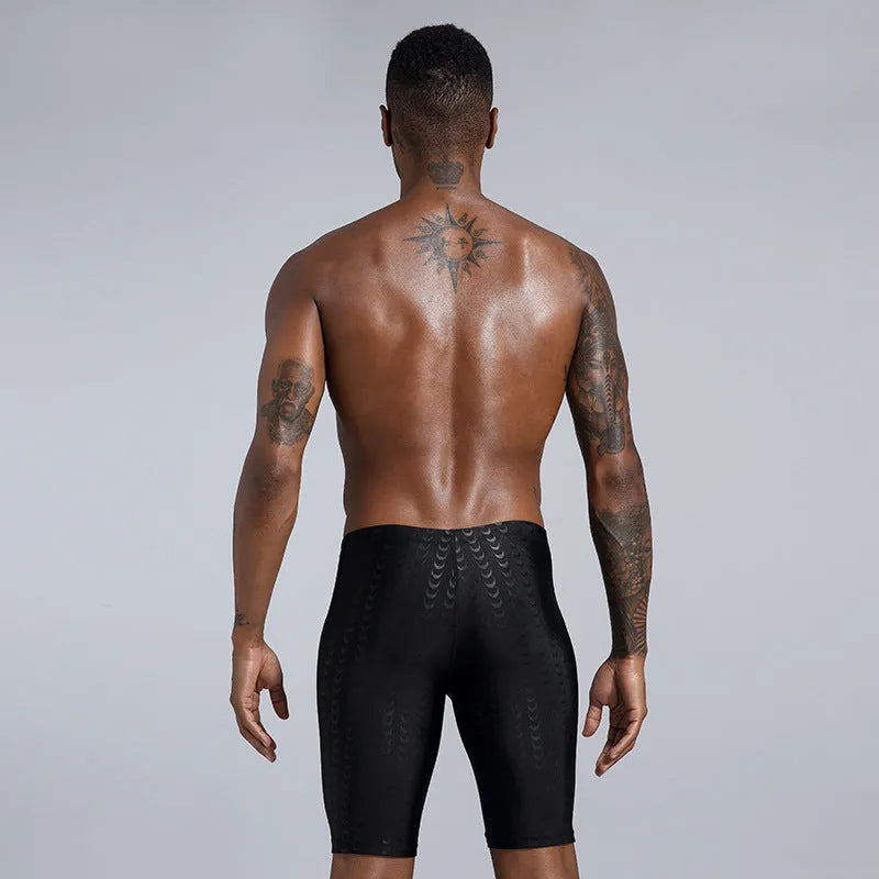 Men's solid colour swimming trunks in shark skin polyester fabric for surfing.