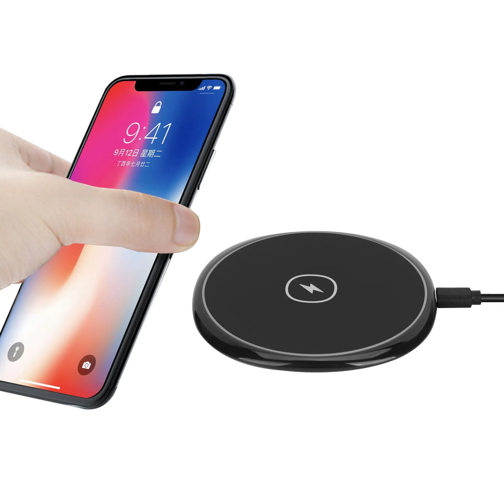 Black 15W fast wireless charger on a desk, glossy surface with indicator light