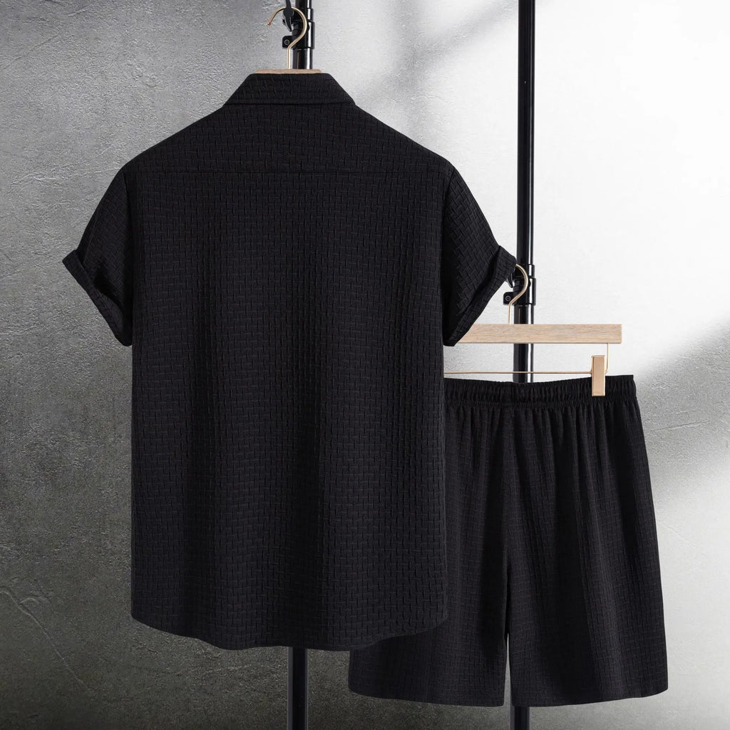 Men's black cotton blend short sleeve shirt and shorts beach suit laid flat.