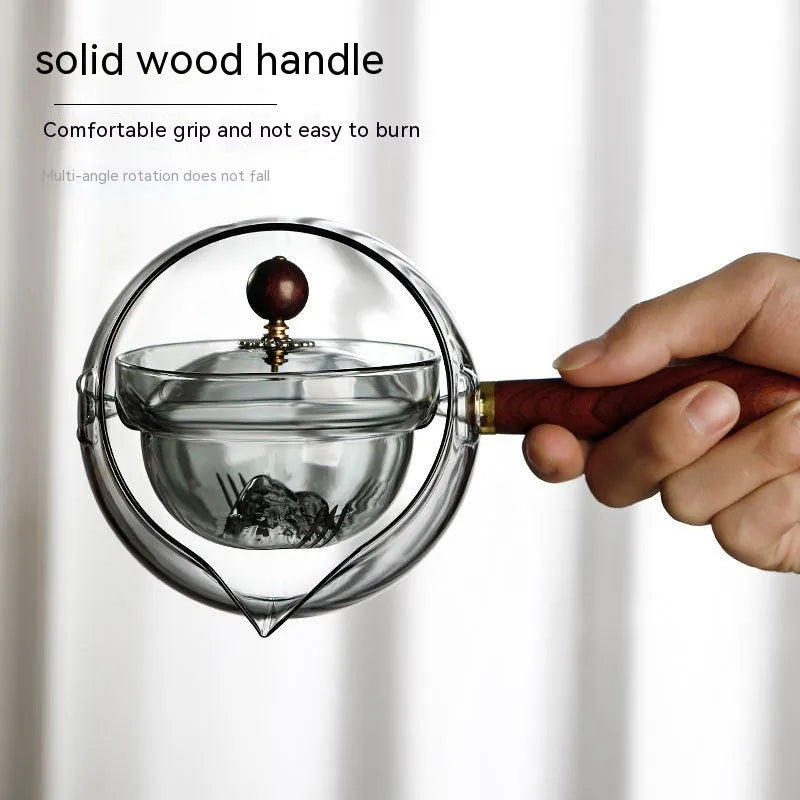 Transparent rotating glass teapot with wooden handle and integrated tea infuser
