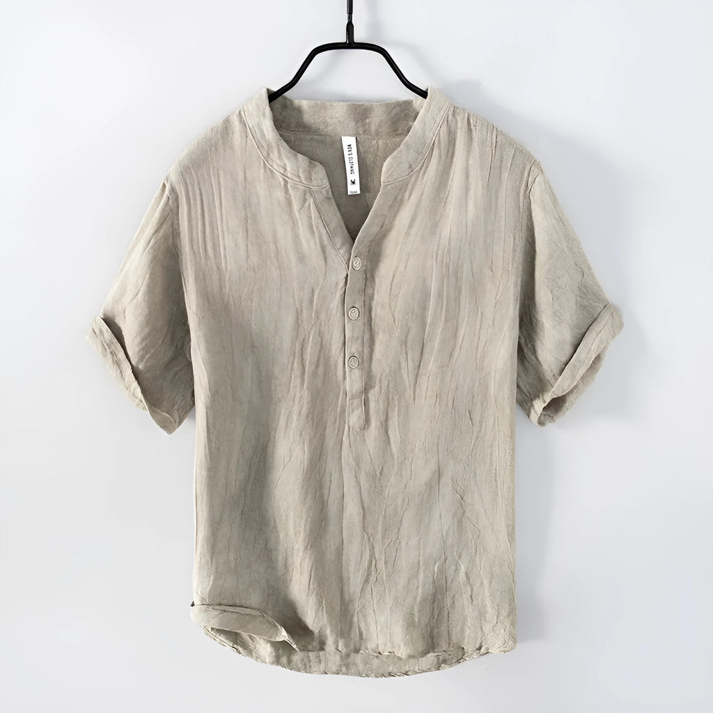 A grey linen short sleeve pullover top with a stripe pattern, laid flat.