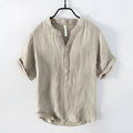 A grey linen short sleeve pullover top with a stripe pattern, laid flat.