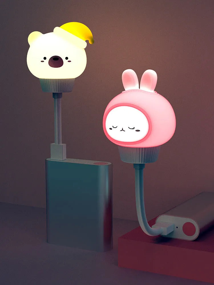 Cute cartoon animal USB night light in bear shape with soft white glow on a bedside table.