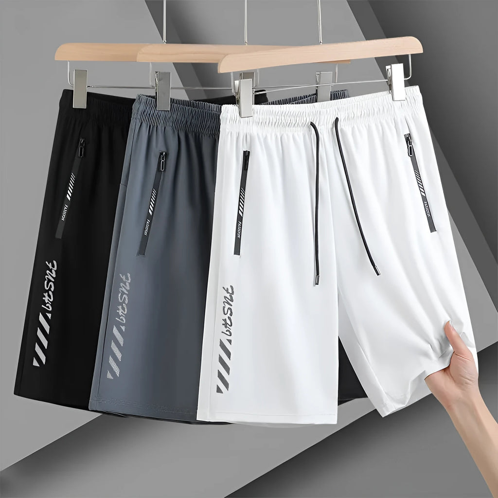 Man wearing black loose-fit quick-drying nylon sports shorts with an elastic waistband.