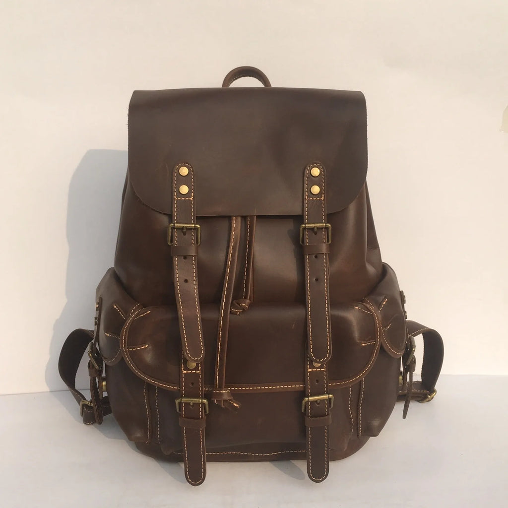 Brown men's leather backpack showing genuine cowhide material and integrated air pillow shoulder straps.