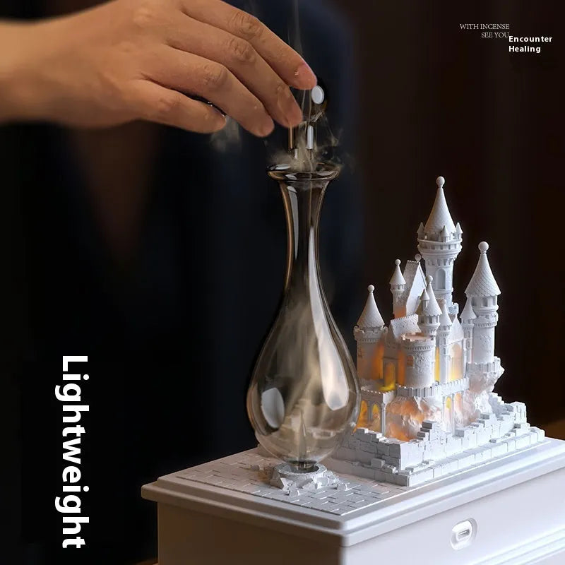 White Medieval Castle waterless aromatherapy machine ornament with ambient light on a table.