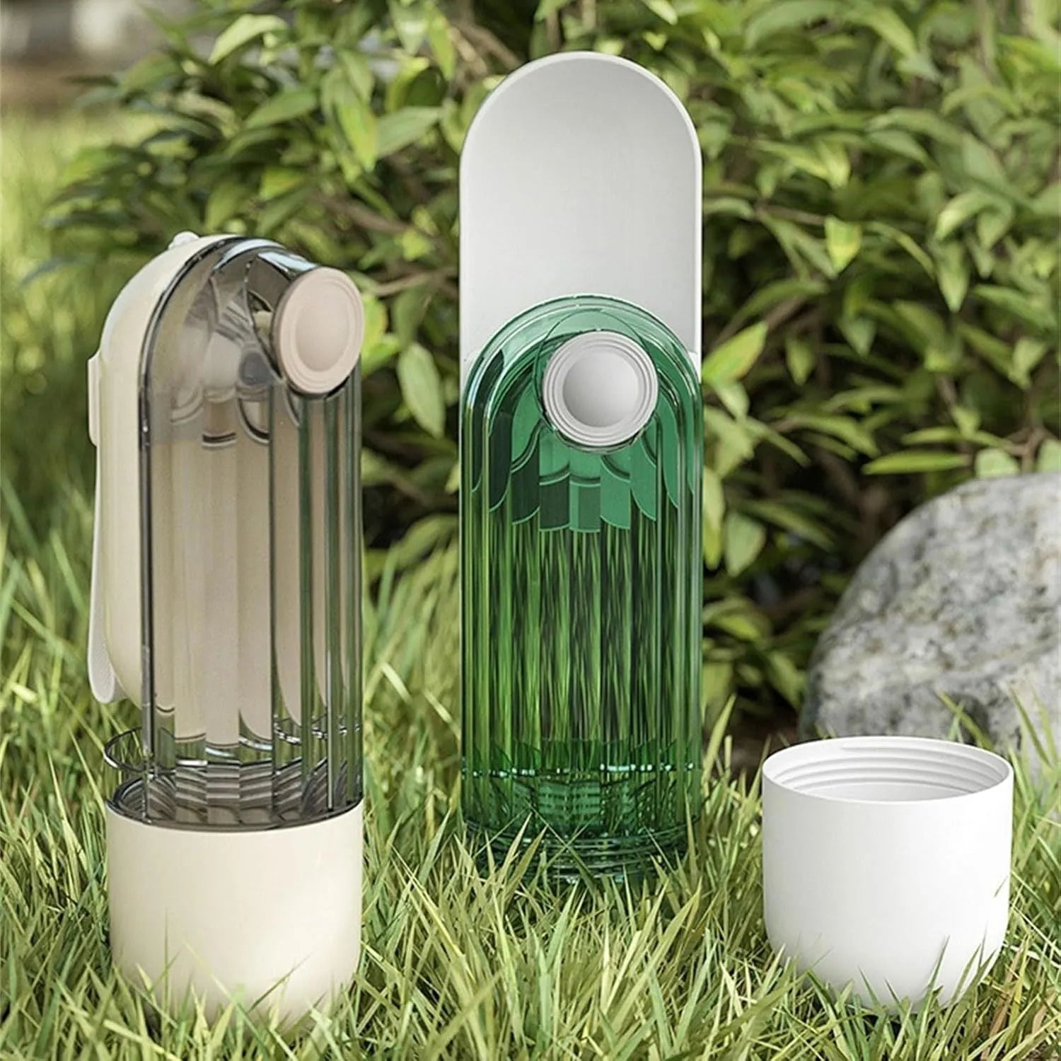 Beige foldable dog water bottle and food dispenser with press mechanism, shown next to a green version.