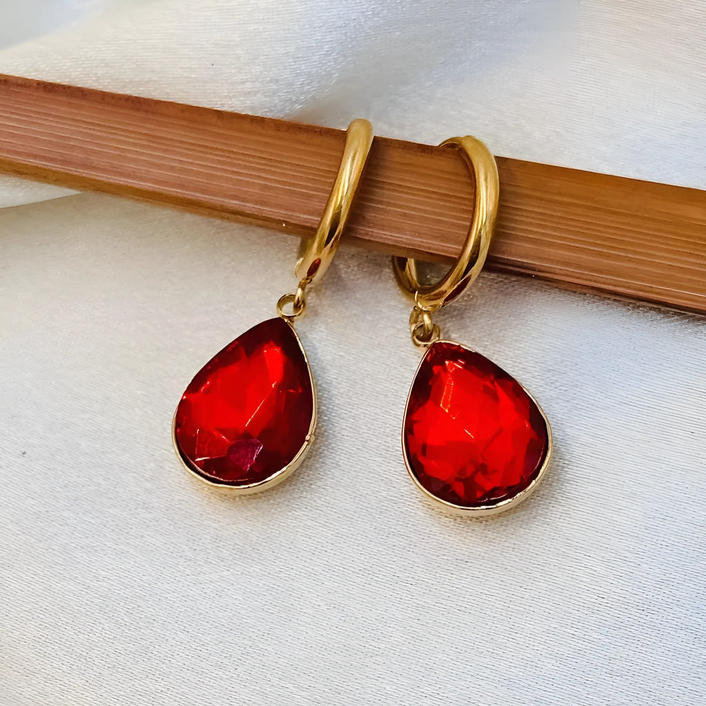 Copper and glass water drop earrings with a carved Saturn ring design in a geometric shape.