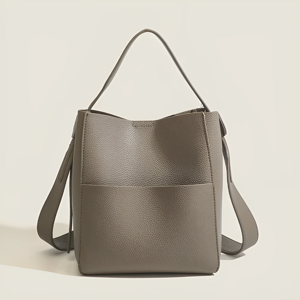 Soft PU bucket messenger bag in elephant gray with visible sewing line detailing, outer sandwich pocket, and single shoulder strap.