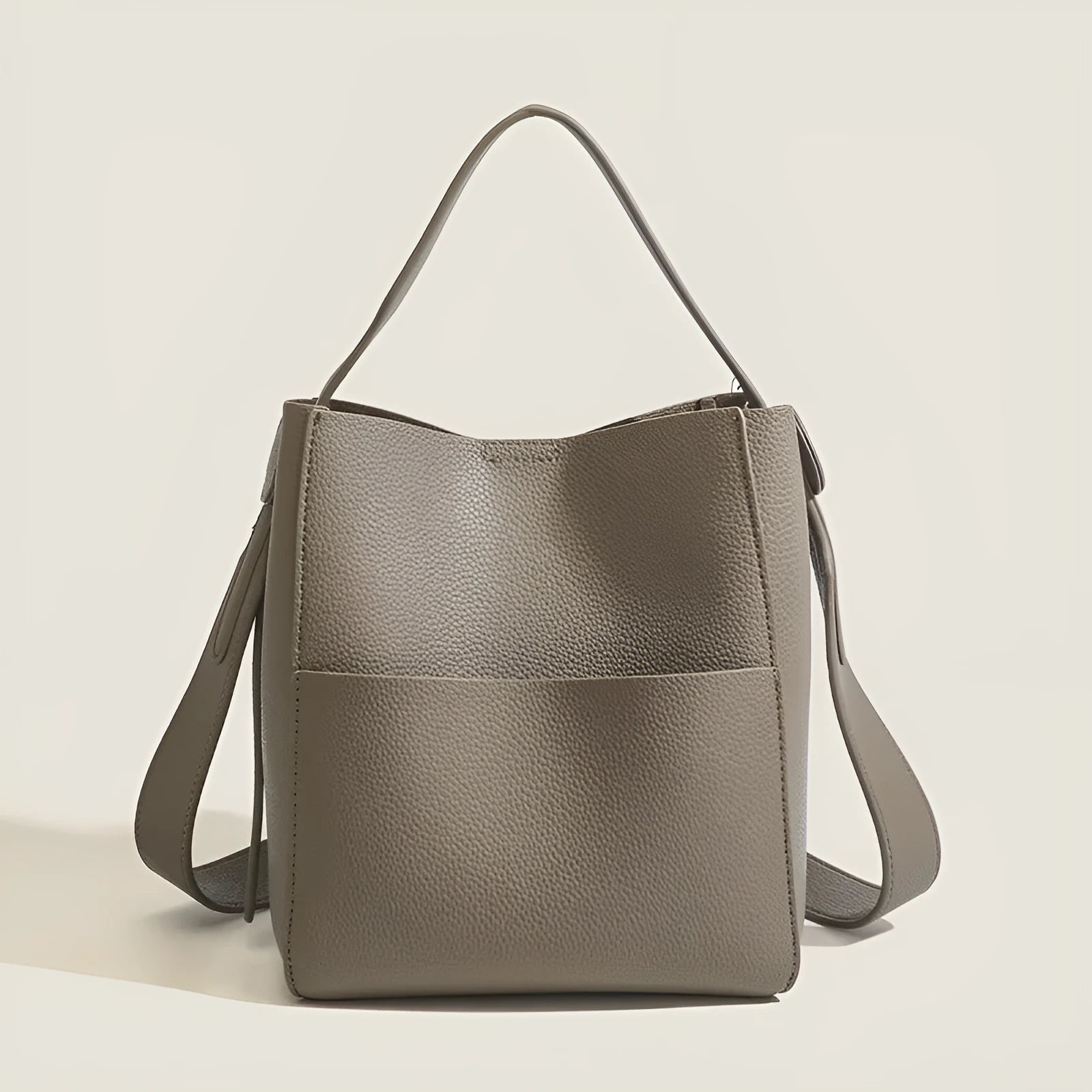 Soft PU bucket messenger bag in elephant gray with visible sewing line detailing, outer sandwich pocket, and single shoulder strap.