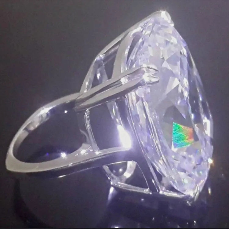 Women's white gold colour ring with a simple inlaid square diamond geometric design on a finger.