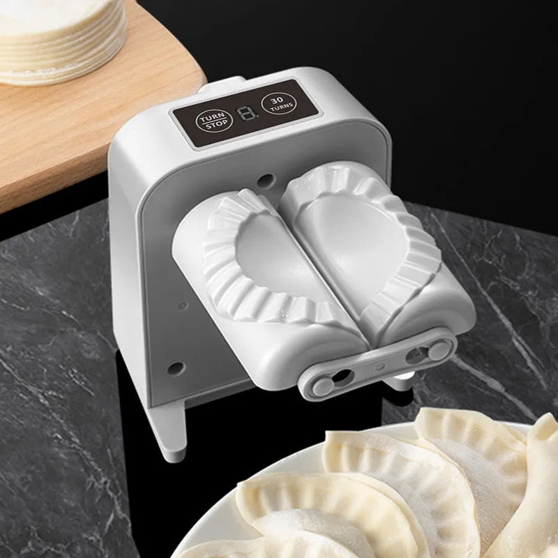 White electric dumpling maker machine with USB charging cable and accessories on kitchen counter