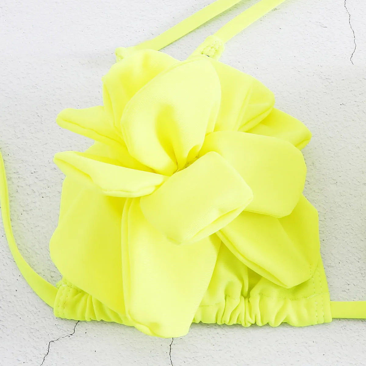 Low waist bikini swimsuit with 3D flower design in solid colour.