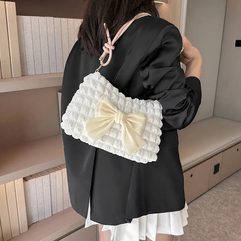 Street style canvas one-shoulder handbag in horizontal square shape with visible stitching.