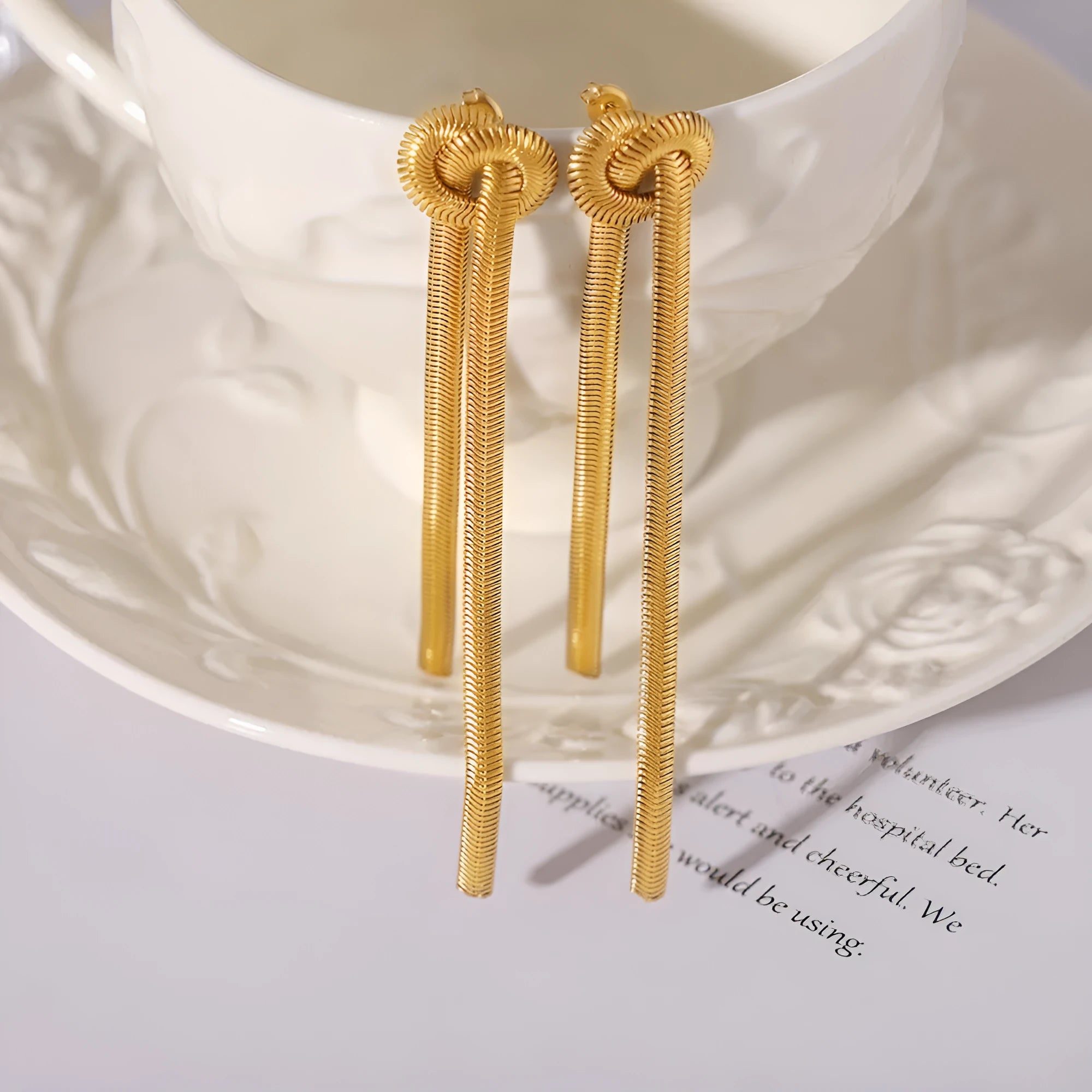 Gold electroplated titanium steel necklace with knotted tassel pendant on snake chain and matching earrings