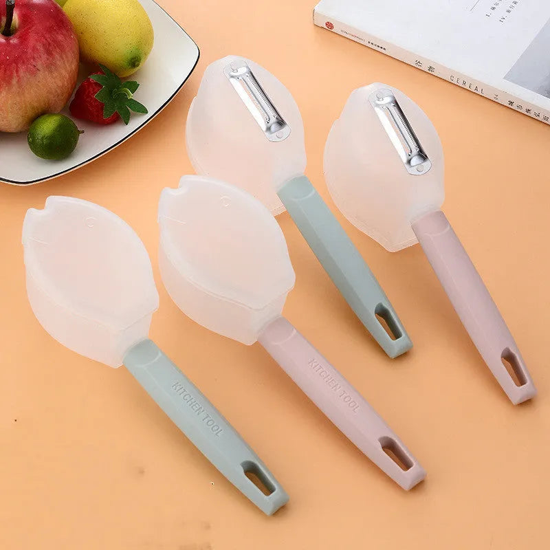 Stainless steel fruit peeler with pink plastic PP handle on light background