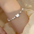 Natural freshwater pearl bracelet with Fu character charm on white background, silver chain, women's accessory
