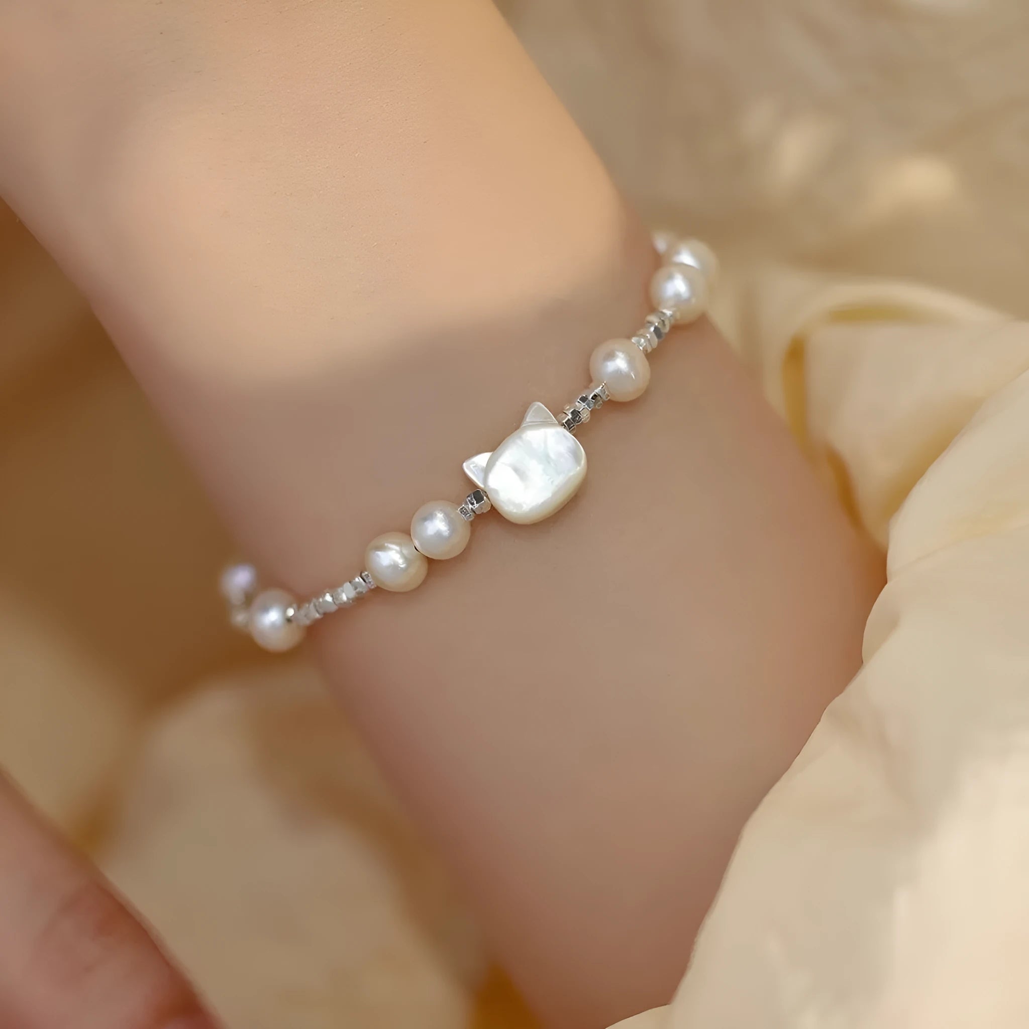 Natural freshwater pearl bracelet with Fu character charm on white background, silver chain, women's accessory