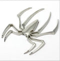 Three-dimensional metal spider bumper sticker in metallic finish measuring 7cm by 5cm