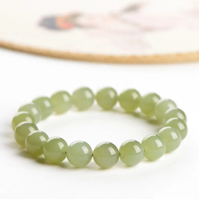 Polished Hetian jade bead bracelet in ice-like clear colours on a white background.