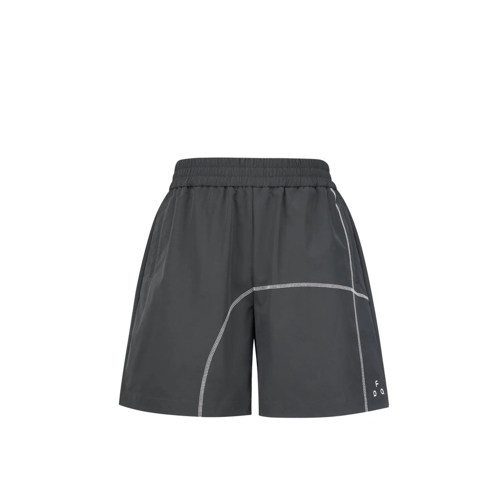 High-elasticity polyester drawstring shorts in apricot colour on a beach background.