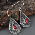 Silver-coloured drop earrings with red pine gemstones in a retro style.