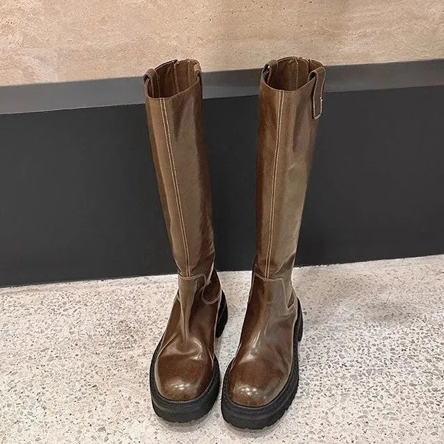 Women's black knee-high knight boots with a chunky heel, round toe, and back zipper.