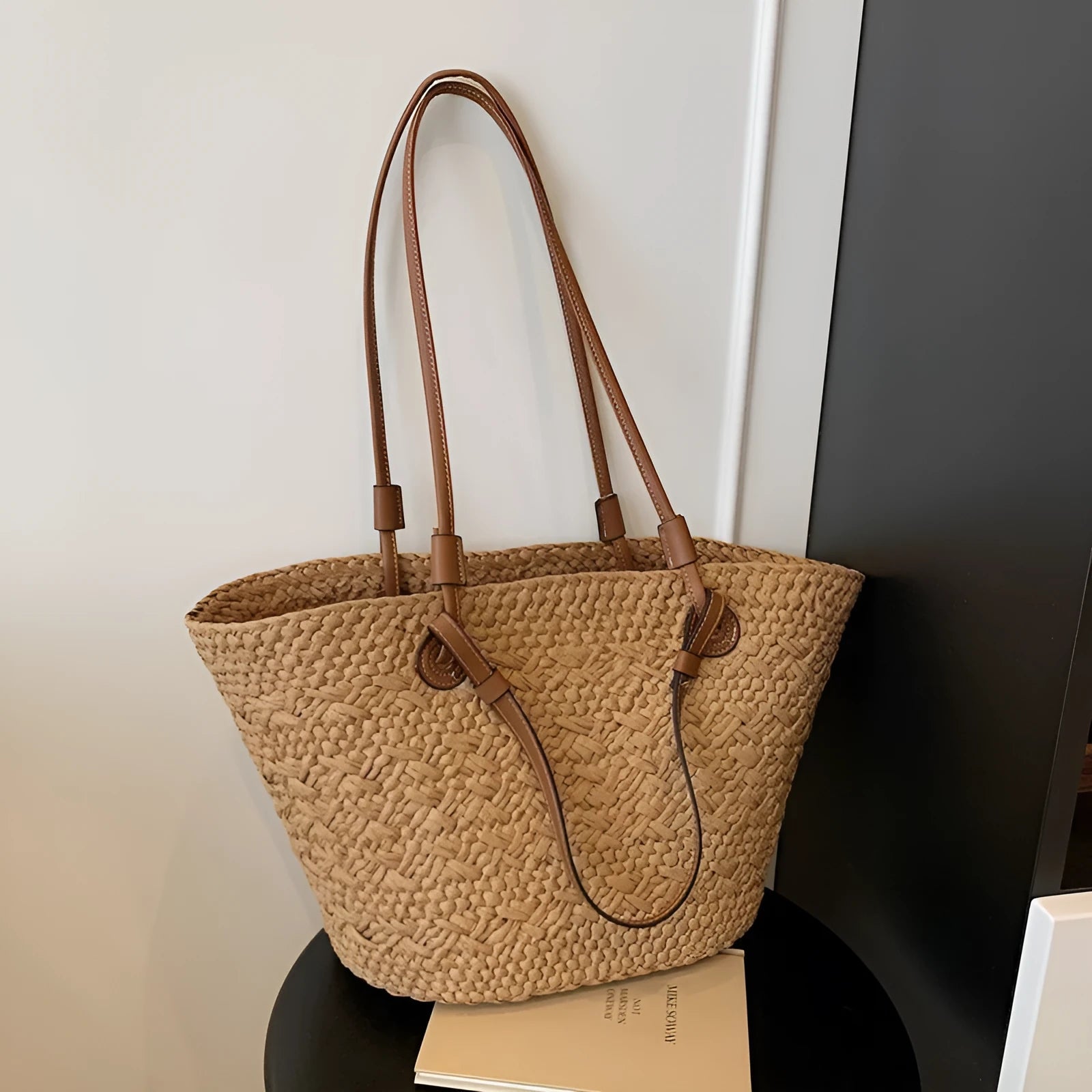 A retro-style horizontal square woven bag in milky white, shown being carried by hand.