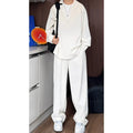 Men's black casual two-piece suit with long sleeve polo shirt and trousers on a hanger