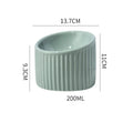 Dark green ceramic elevated cat bowl with tilted, round design on a wooden floor.