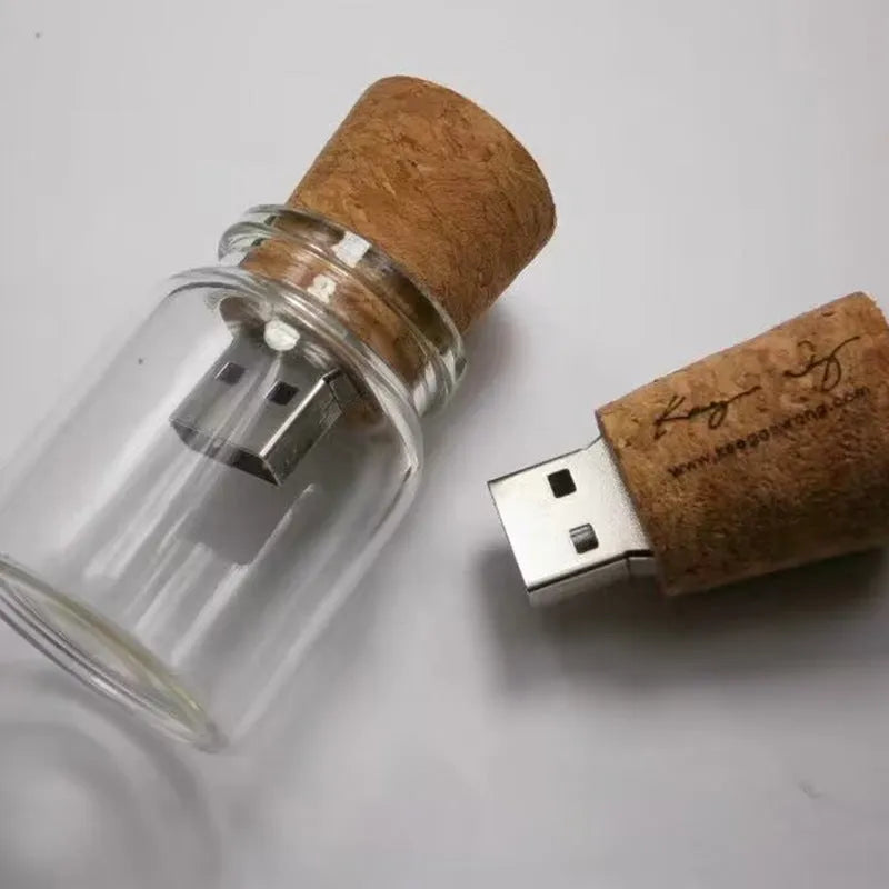 Wooden-lidded transparent glass bottle-shaped USB flash drive on a white background.