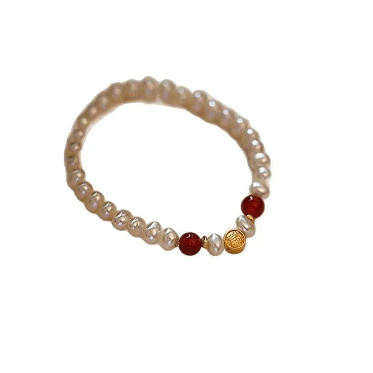 Natural freshwater pearl bracelet with Fu character charm on white background, silver chain, women's accessory