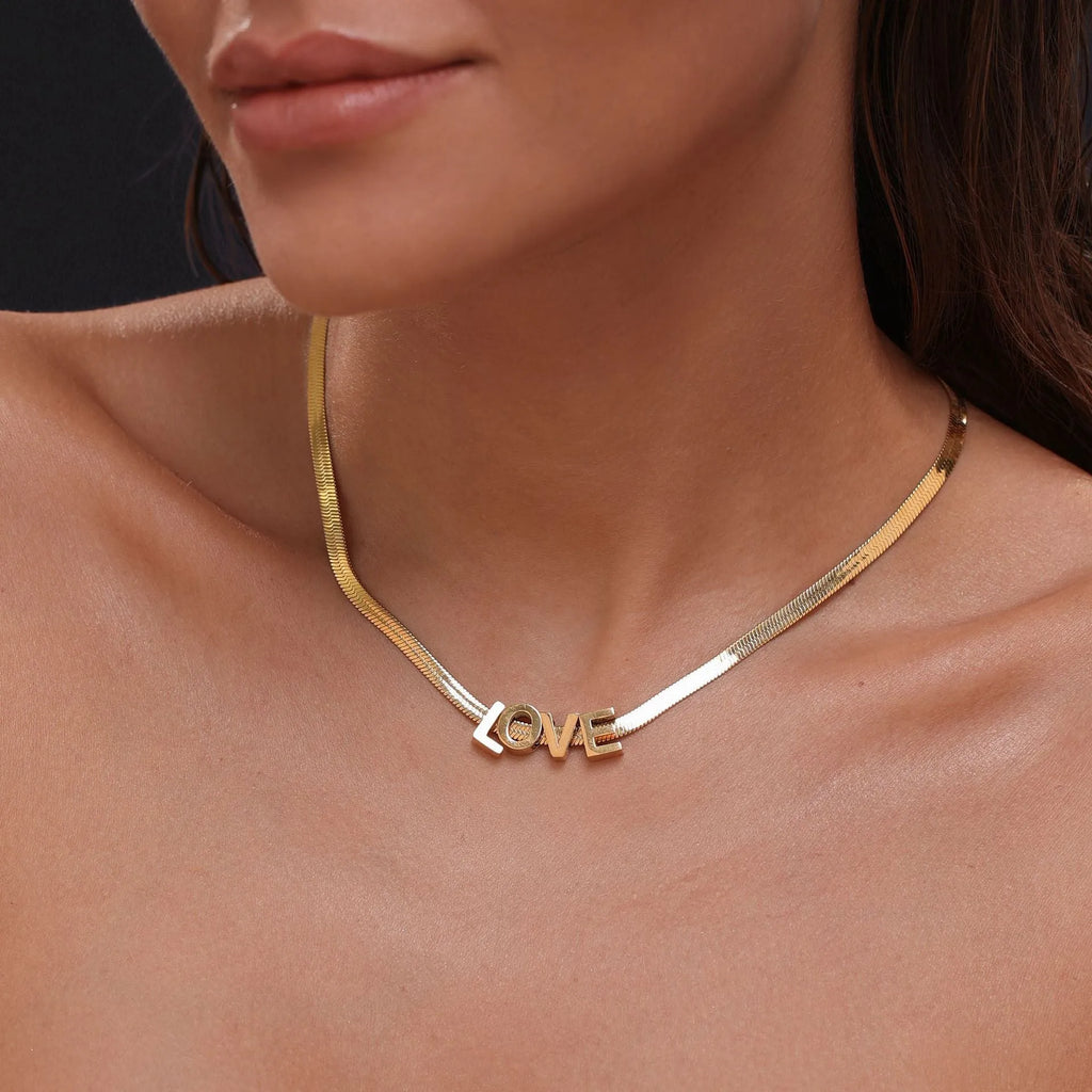 Gold or silver plated titanium steel necklace with a personalised letter, number, or heart pendant on a 40.5cm chain.
