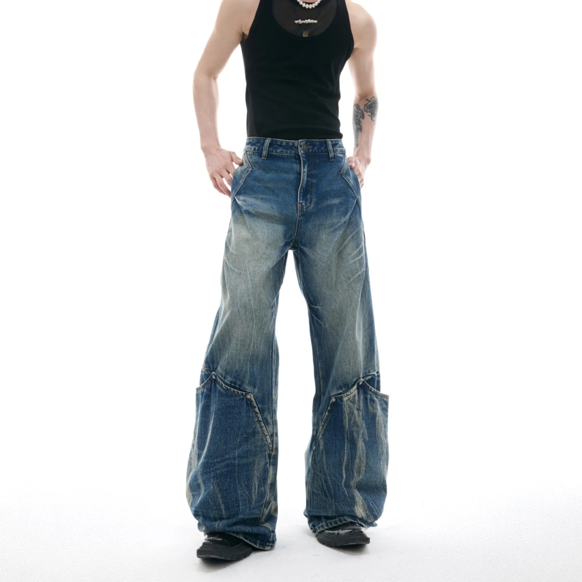 Man wearing verdant blue loose-fit retro jeans with a washed burst pattern.