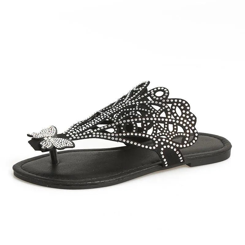 Women's black slip-on sandals with rhinestone decoration and a flip-toe, hollow design.
