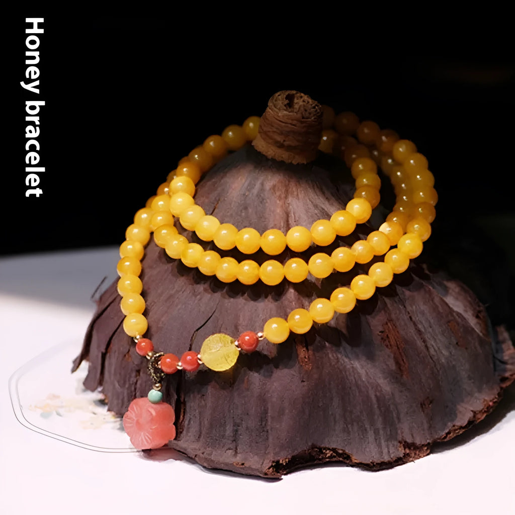 Yellow chicken grease beeswax amber bracelet with 5mm round beads and animal zodiac design.