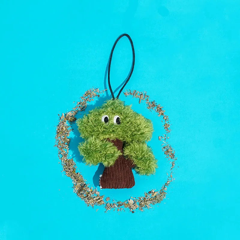 Pine tree shaped hanging cat toy with textured surface and bag of catnip.