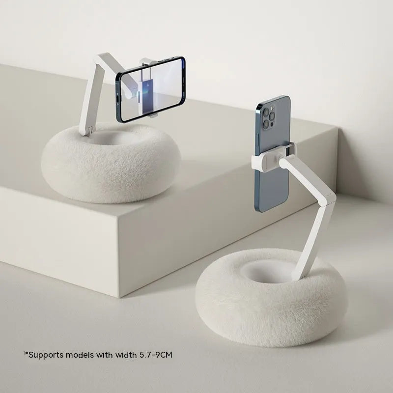 Adjustable rotating phone and tablet bracket on a desk, showing the clamp and fabric base.