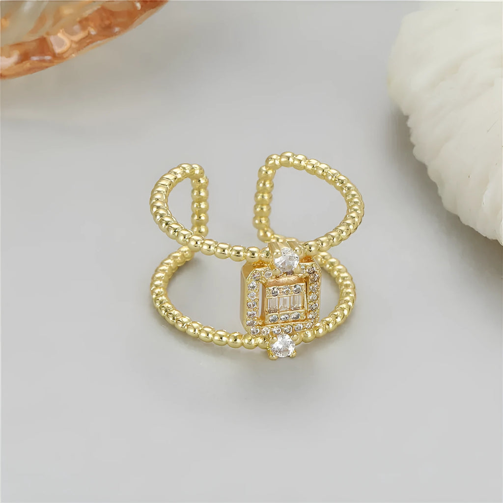 Gold-plated copper open ring with asymmetric U-shape and adjustable gap.