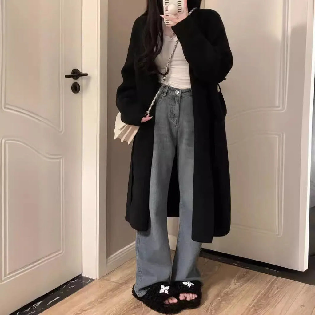A woman's loose-fit knitted cardigan in a khaki colour with a V-neck and long sleeves, laid flat.