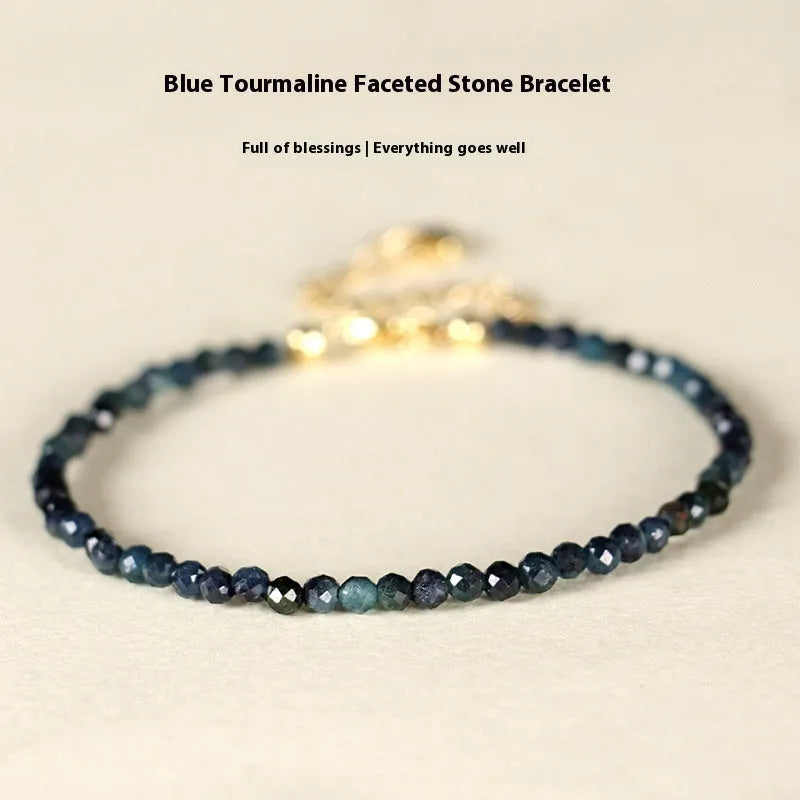 Close-up of a women's bracelet with 3mm blue tourmaline cut beads and silver-toned spacer beads on a wrist.