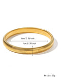 Gold women's elastic bracelet with a wide vertical stripe pattern, shown on a wrist.