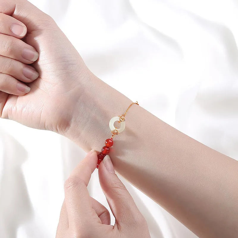 Close-up of a women's sterling silver bracelet with a peace buckle, xiangyun cloud patterns, and a Fu character.