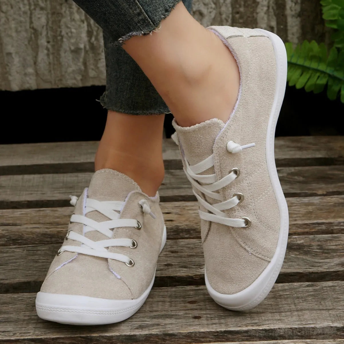 Women's creamy-white low-top fabric casual sneakers with a rubber sole on a neutral background.