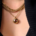 Gold-plated copper teapot pendant necklace with round red gemstone accent on regular chain, opened to show storage compartment