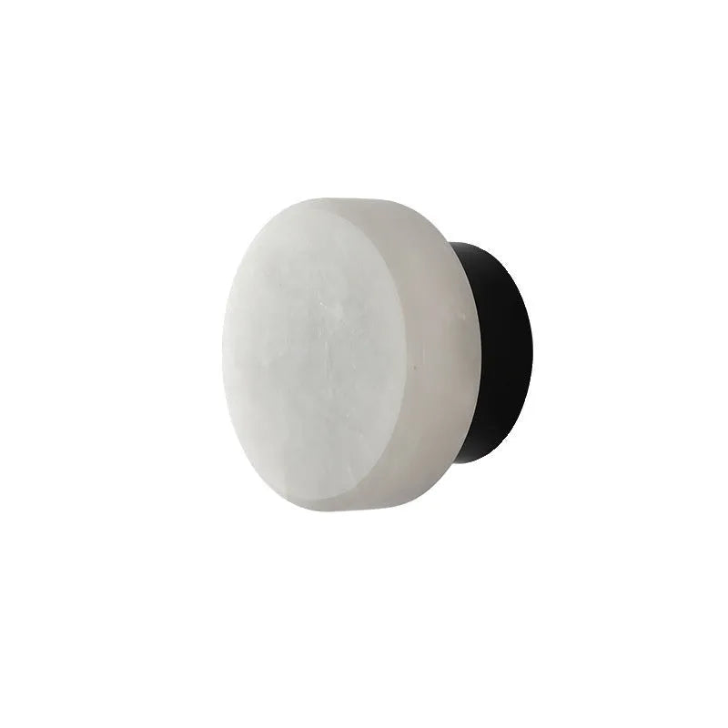 Spanish natural marble round wall lamp with warm light, 130mm diameter, black finish on a bedroom wall
